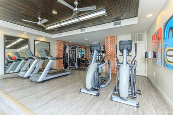 A gym with treadmills, exercise bikes, and weight machines.